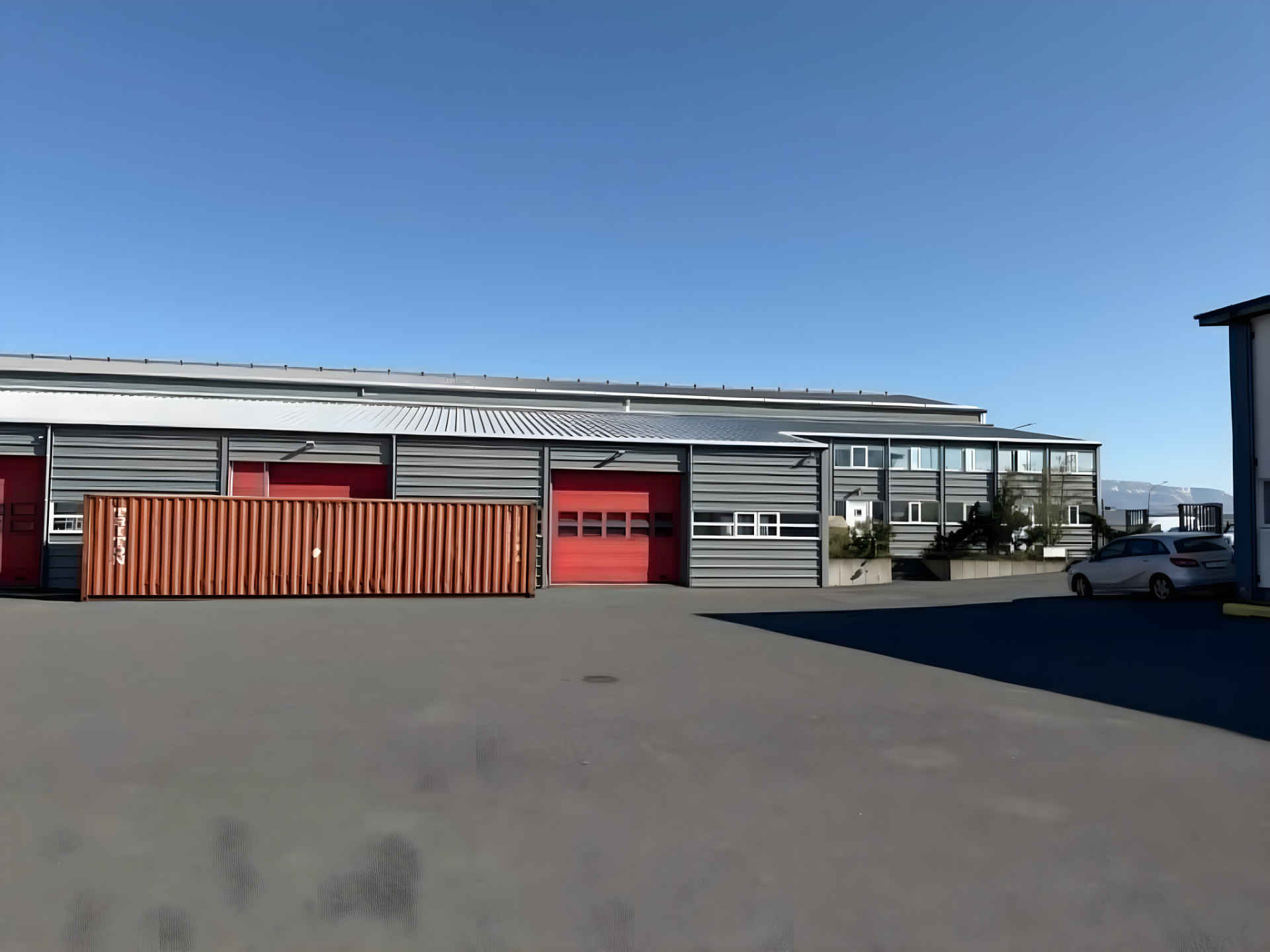 Propack yard with a shipping container and red loading doors